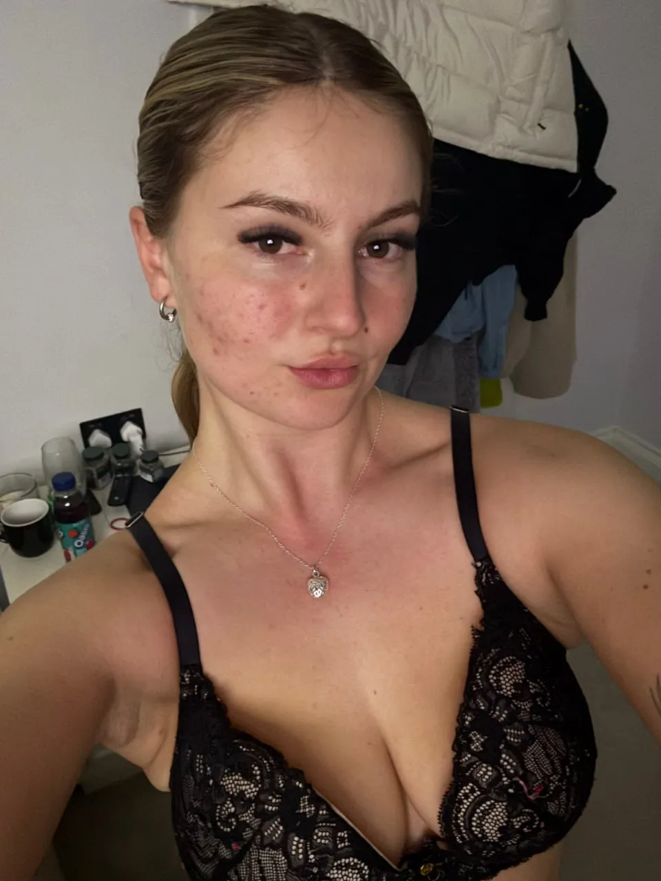 Young brunette OnlyFans model taking a selfie in black lace lingerie with natural makeup and tied-back hair